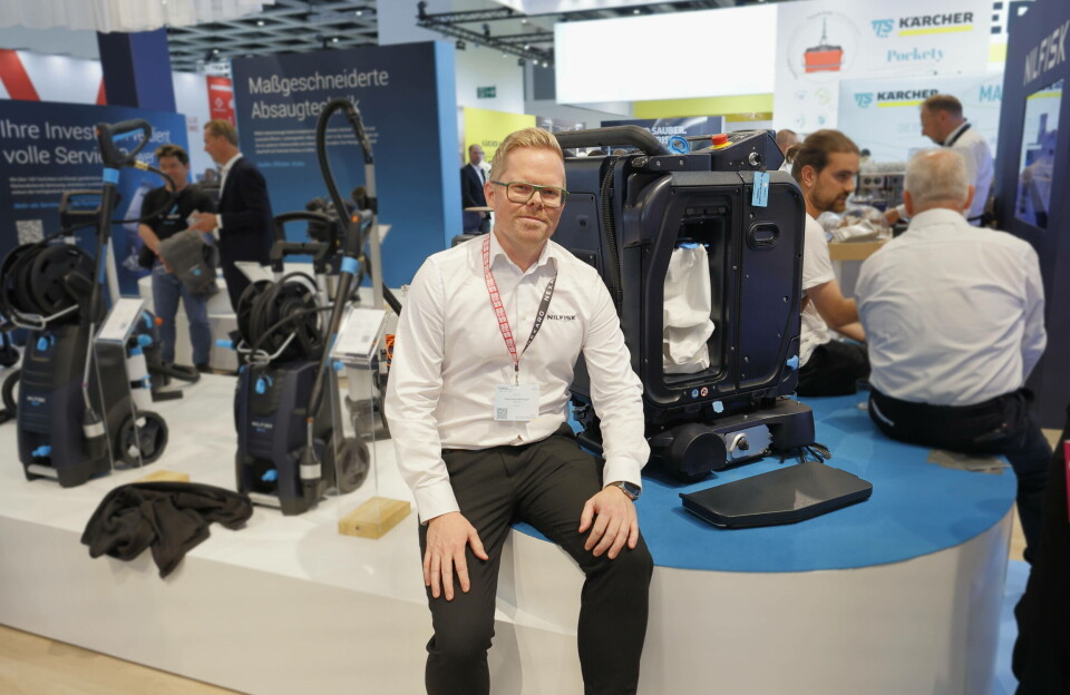 Martin Nordahl-Angell hos Nilfisk viser roboten VP25. Fotografert under renholdsmessa CMS Berlin 2025. Mann sittende ved siden av profesjonell robotstøvsuger