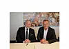 To menn i dress, sittende bak et skrivebord