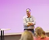 Portrettfoto av ham, stående foran et lerret