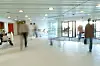 Inngangsparti i en bygning. Flere mennesker i bevegelse og derfor uskarpe. Langtidseksponering.