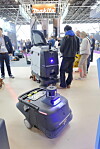 To profesjonelle gulvrengjøringsroboter med tilskuere rundt, på messe