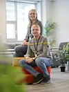 En kvinne og en mann sitter på fargerike puffer i en sofakrok.
