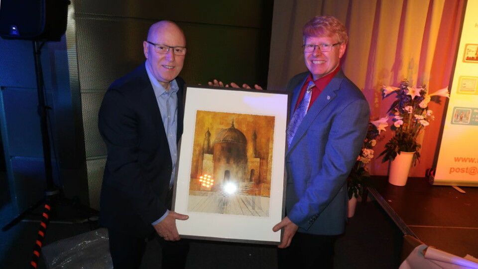 Trond Holm Johansen (til venstre) mottar Renholds­nytts heders­pris for 2019. Gaven er maleriet «Reisen» av kunstneren Ellen Hegg, og det over­rekkes av journalist Trond Erik Hillestad i Renholdsnytt. (Foto: Pål Sønsteli).