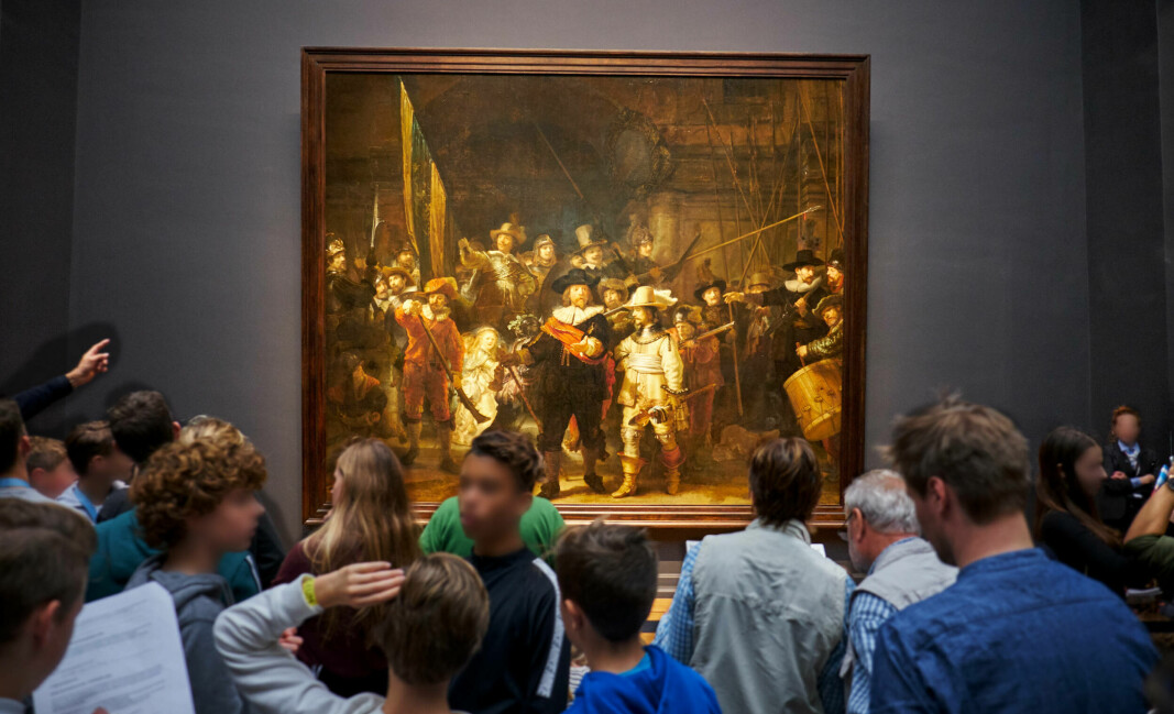 I bakgrunnen ses «Nattevakten» av Rembrandt i Amsterdams Rijksmuseum.