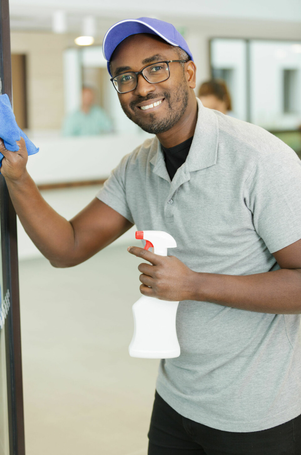 Illustrasjonsbilde av mannlig renholder som rengjør et vindu