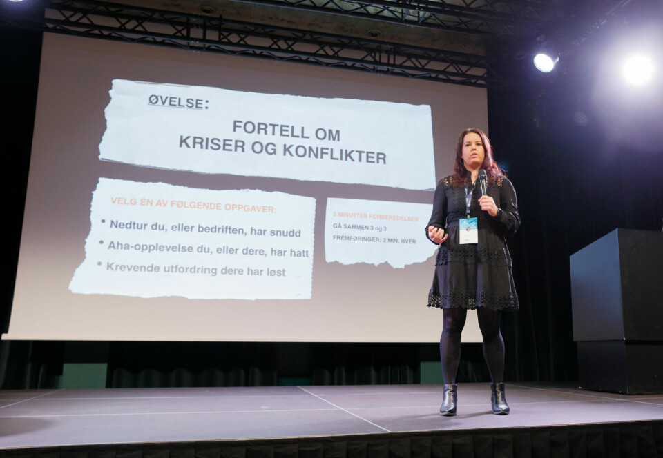 Foto av Hjelle på en scene, idet hun holder et innlegg om saken under årskonferansen til Norsk Forening for Service og Renhold i Bergen i 2022.